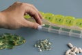 Woman hands put pills in pill box. selective focus