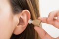 Woman Hands Putting Hearing Aid In Ear Royalty Free Stock Photo