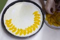 Woman hands putting pieces of apricot on the raw dough close up