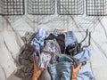 Woman hands putting stack of clean clothes for neatly tidying up and placing in steel wire wardrobe