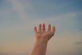 Woman hands reach out to the sky like praying.