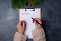 Woman hands ready to write goals on blank list on dark background. Flat lay. Top view. New year concept. Target success Royalty Free Stock Photo