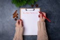 Woman hands ready to write new year`s resolutions on blank list on dark background. Flat lay. Top view. New year concept Royalty Free Stock Photo