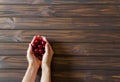 Woman hands with  red cherries on dark wooden desk background. Flat lay. Top view. Backdrop Royalty Free Stock Photo