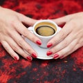 Woman hands with red manicure and cup of fresh hot coffee Royalty Free Stock Photo