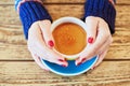 Woman hands with red manicure and cup of fresh hot coffee on wooden table Royalty Free Stock Photo