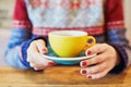 Woman hands with red manicure and cup of fresh hot coffee on wooden table Royalty Free Stock Photo