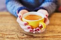 Woman hands with red manicure and cup of fresh hot coffee on wooden table Royalty Free Stock Photo