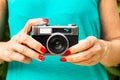 Woman hands with red nails holding a vintage photographic camera