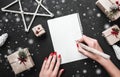 Woman hands with red nails writing letter with silver pen. Xmas background. Royalty Free Stock Photo