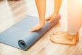 Woman hands rolled up yoga mat on gym floor in yoga fitness training room. Home workout woman close up hands rolling