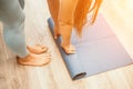 Woman hands rolled up yoga mat on gym floor in yoga fitness training room. Home workout woman close up hands rolling Royalty Free Stock Photo