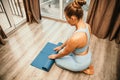 Woman hands rolled up yoga mat on gym floor in yoga fitness training room. Home workout woman close up hands rolling