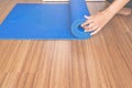 Woman hand rolling or folding blue yoga mat after a workout,Exercise equipment Healthy fitness and sport concept,Close up Royalty Free Stock Photo