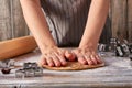 Woman hands rolls up gingerbread dough on table