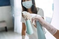Woman hands in rubber protective glove spraying detergent to cleaning a mirror surface in bedroom at home. Closeup