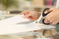 Woman hands with scissors cutting paper on a desk Royalty Free Stock Photo