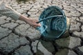 Woman hands are scooping water on cracked ground. Royalty Free Stock Photo