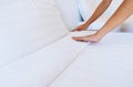 Woman hands set up white bed sheet in hotel room