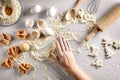 Baking preparation. Raw dough and cutters for the holiday cookies on a white table. Top view. Royalty Free Stock Photo