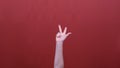 Woman hands showing fingers ordinal count from 5 to 0 and thumbs up gesture isolated over red background in studio.