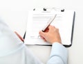 Woman hands signing a contract, isolated on desk