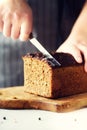 Woman hands slicing freshly backed bread. Handmade brown loaf of bread, bakery concept, homemade food, healthy eating Royalty Free Stock Photo