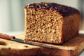 Woman hands slicing freshly backed bread. Handmade brown loaf of bread, bakery concept, homemade food, healthy eating Royalty Free Stock Photo