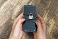 Woman hands and smartphone tied with metallic chain and padlock