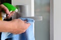 Woman hands spraying cleaning detergent on home door handle Royalty Free Stock Photo