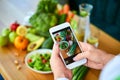 Woman hands take smartphone food photo of vegetables salad with tomatoes and fruits. Phone photography for social media or Royalty Free Stock Photo