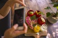 Woman hands takes photography of food on table with phone for internet blog. Smartphone photo for vegetarian, healthy and organic Royalty Free Stock Photo