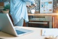 Woman hands taking photo of coffee cup, green leaves and breakfast at home in brown kitchen at smartphone. Top view. Royalty Free Stock Photo