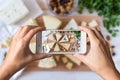 Woman hands taking a photo of different kinds of delicious cheese