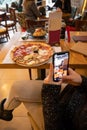 Woman hands taking picture, with smartphone, of the food served in the restaurant Royalty Free Stock Photo