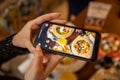 Woman hands taking picture, with smartphone, of the food served in the restaurant Royalty Free Stock Photo