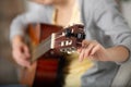 woman hands tunes six stringed guitar in backstage sitting