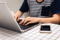 Woman hands typing on keyboard laptop computer for working, shopping online, searching information with smart phone on table Royalty Free Stock Photo