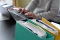 Woman hands typing on laptop computer with binders filled with papers in foreground. Selective focus Royalty Free Stock Photo