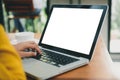 Woman hands typing laptop computer with blank screen on table in coffee shop. Blank laptop screen mock up for display of design. Royalty Free Stock Photo