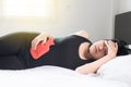 Woman hand using hot water bag or bottle on her belly and sleep on bedroom,Stomachache,Abdominal surface Royalty Free Stock Photo