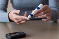 Woman hands using lancet on finger to check blood sugar level