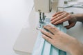 Woman hands using the sewing machine to sew the face home made diy medical mask during the coronavirus pandemia. Royalty Free Stock Photo