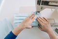 Woman hands using the sewing machine to sew the face home made diy medical mask during the coronavirus pandemia Royalty Free Stock Photo