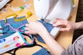 Woman hands using the sewing machine to sew the face mask during the coronavirus pandemia. Domestic sewing due to the shortage of Royalty Free Stock Photo