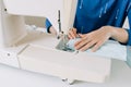 Woman hands using the sewing machine to sew the face home made diy medical mask during the coronavirus pandemia Royalty Free Stock Photo