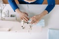 Woman hands using the sewing machine to sew the face home made diy medical mask during the coronavirus pandemia. Royalty Free Stock Photo