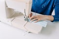 Woman hands using the sewing machine to sew the face home made diy medical mask during the coronavirus pandemia. Royalty Free Stock Photo