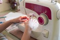 Woman hands using sewing machine to sew white cotton face medical mask. DIY or individual protect on quarantine concept. Soft Royalty Free Stock Photo