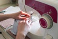Woman hands using sewing machine to sew white cotton face medical mask. DIY or individual protect on quarantine concept. Soft Royalty Free Stock Photo